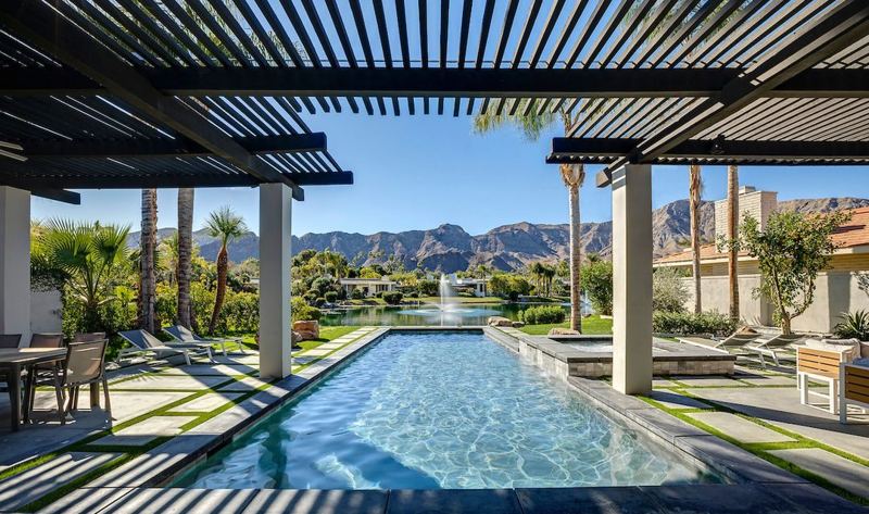 Lap pool beneath a pergola with mountain views